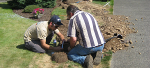 two techs repair a broken underground line