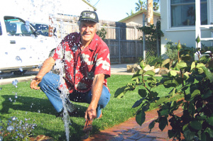 an Ellicott City Sprinkler Repair specialist checks the water pressure at the end of a pop up head run